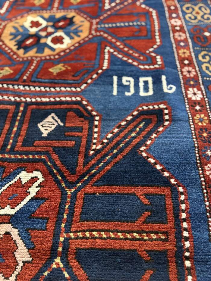 An antique Caucasian rug dated 1906